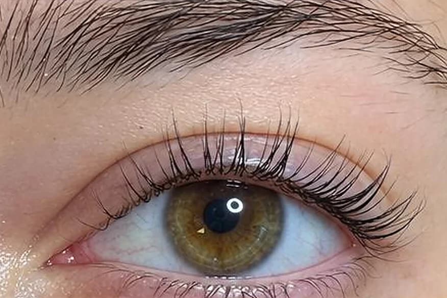 Nach dem Wimpernlifting im Studio: geliftete, geschwungene Wimpern an einem Auge